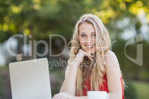 Woman with hand on chin using laptop