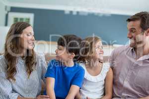 Smiling family sitting on sofa in living room
