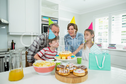 Family celebrating their sons birthday in kitchen