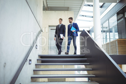 Two businessman walking down the stairs