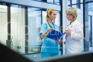 Female doctor and nurse discussing over a medical report