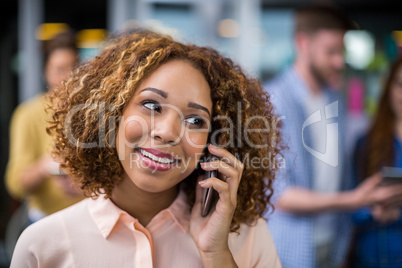 Smiling female executive talking on mobile phone