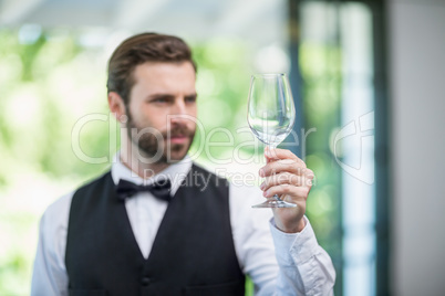 Male waiter holding wine glass in the restaurant
