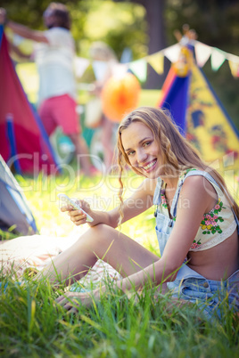 Woman holding mobile phone at campsite