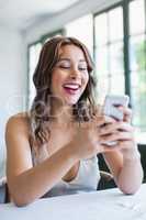 Beautiful woman smiling while using her mobile phone