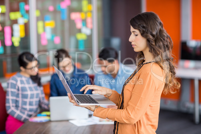 Attentive female graphic designer using laptop