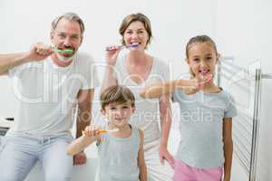 Smiling family brushing their teeth with toothbrush at home