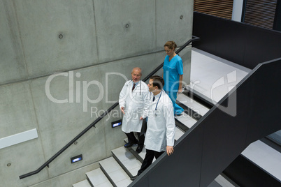 Doctors and surgeons interacting with each other on staircase