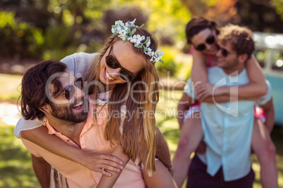 Men giving piggyback rides to women