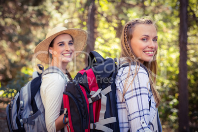 Two female friends walking together in forest