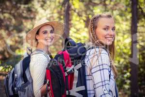 Two female friends walking together in forest