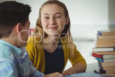 Smiling school kids interacting in library