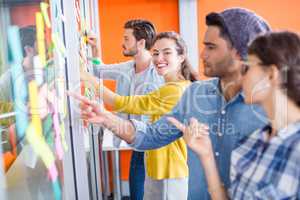 Executives reading sticky notes on glass wall