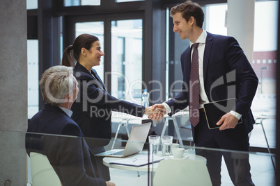 Businesspeople shaking hands in a lobby