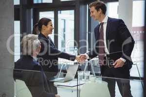 Businesspeople shaking hands in a lobby