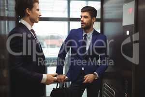 Businessmen interacting with each other in elevator