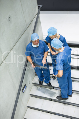 High angle view of surgeons discussing x-ray on staircase