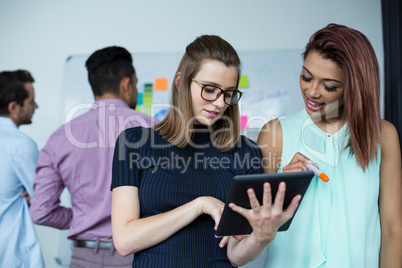 Business executives discussing over digital tablet