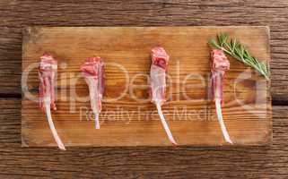 Rib chop and rosemary herb on on wooden tray against wooden background