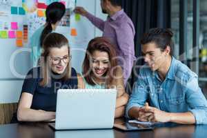 Businesspeople having discussion over laptop in office