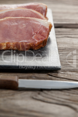 Sirloin chop on black slate plate with knife