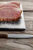 Sirloin chop on black slate plate with knife