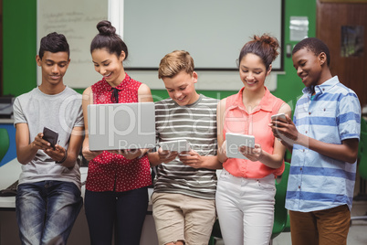 Students using laptop, mobile phone, digital tablet