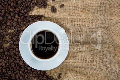 Coffee cup with coffee beans on sack