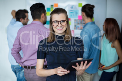 Smiling business executive using digital tablet in office