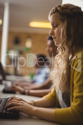 Smiling schoolgirl studying in computer classroom