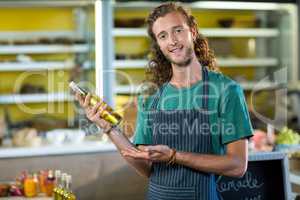 Shop assistant showing a bottle of olive oil