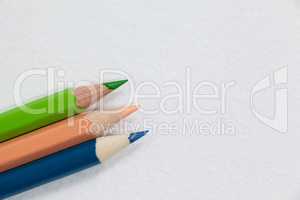 Three colored pencils on white background