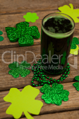 Glass of green beer, beads and shamrock for St Patricks Day