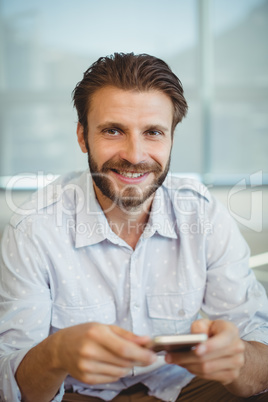 Portrait of male business executives using mobile phone