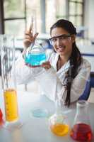 Portrait of happy schoolgirl doing a chemical experiment in laboratory