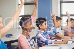 Student raising hand in classroom