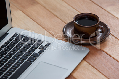 Cup of black coffee and laptop