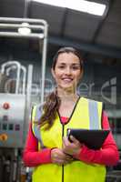 Female factory worker holding digital tablet