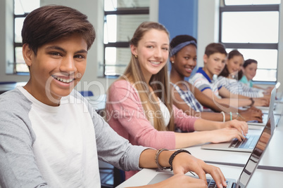 Students using laptop in classroom