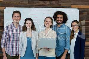 Portrait of smiling business team using laptop