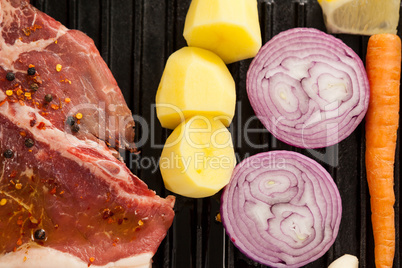 Sirloin chop and ingredients on black grill