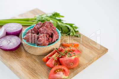 Minced beef and ingredients on wooden tray