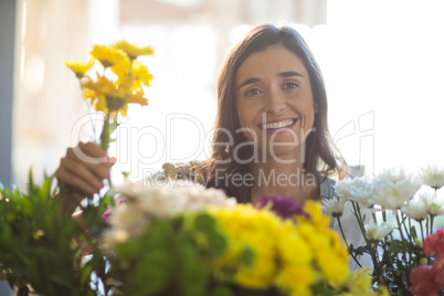 Smiling woman holding a bunch of flowers at florist shop
