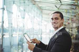 Smiling business executive using digital tablet at railway station