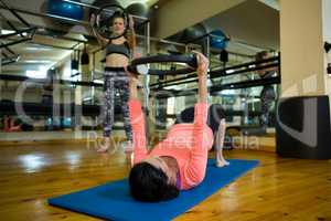 Determined women exercising with pilates ring