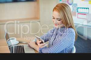 Female graphic designer using mobile phone