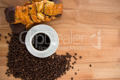 Coffee with roasted coffee beans and croissant