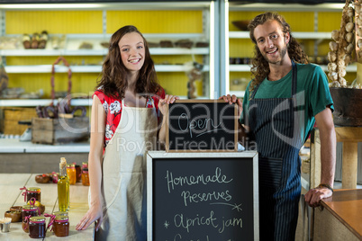 shop assistants holding open sign board