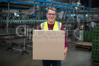 Portrait of factory worker holding cardboard box