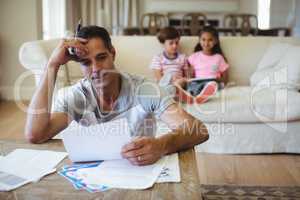 Tense man with hand on forehead sitting in living room